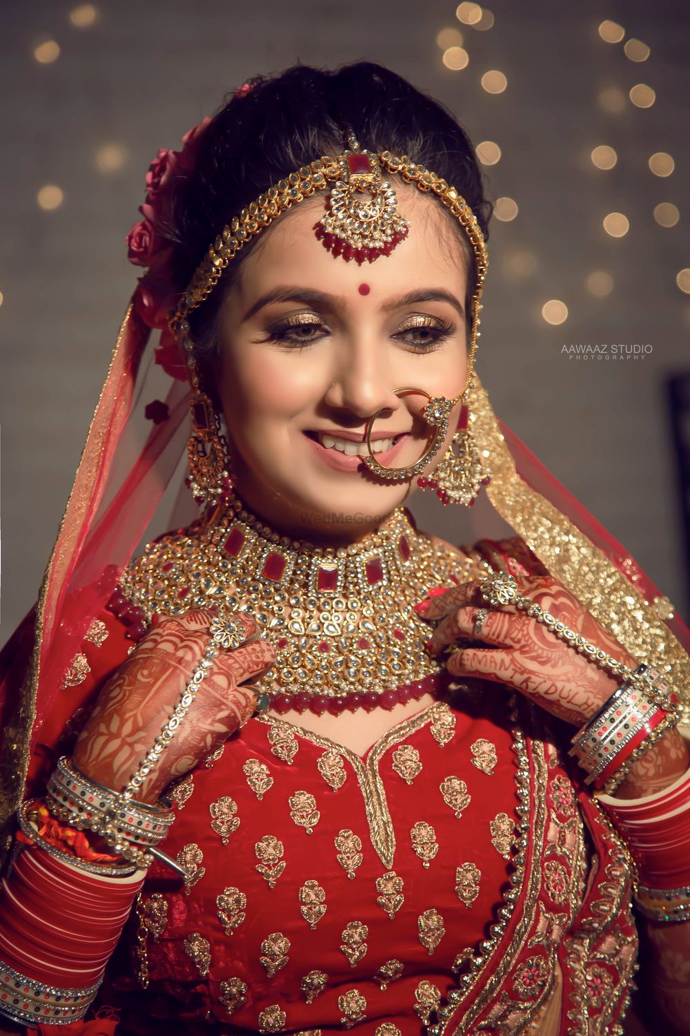 Photo of A happy bridal shot in stunning lehenga and bridal gold jewellery.