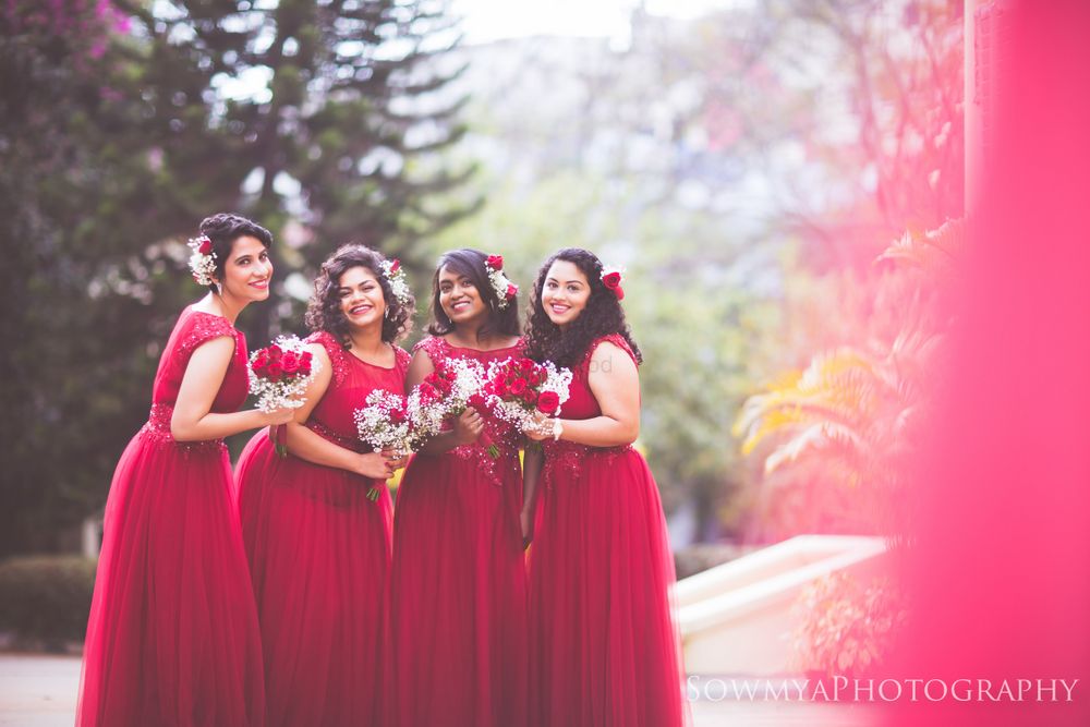 Photo of Color co-ordinated Christian bridesmaids wearing plum color gowns
