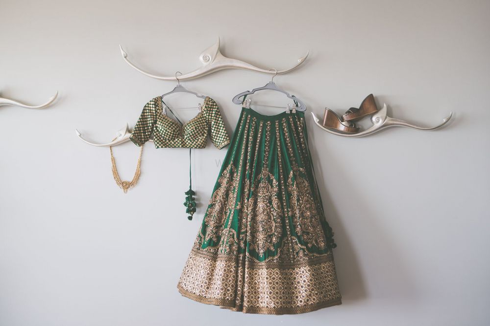 Photo of Offbeat bridal lehnega on hanger in green and gold