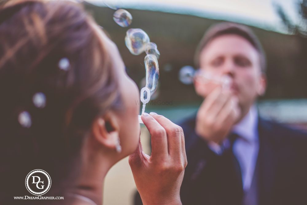 Photo of Christian wedding couple blowing bubbles