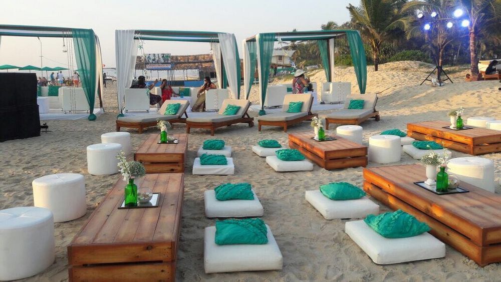Photo of Long table seating with cushions at beach wedding