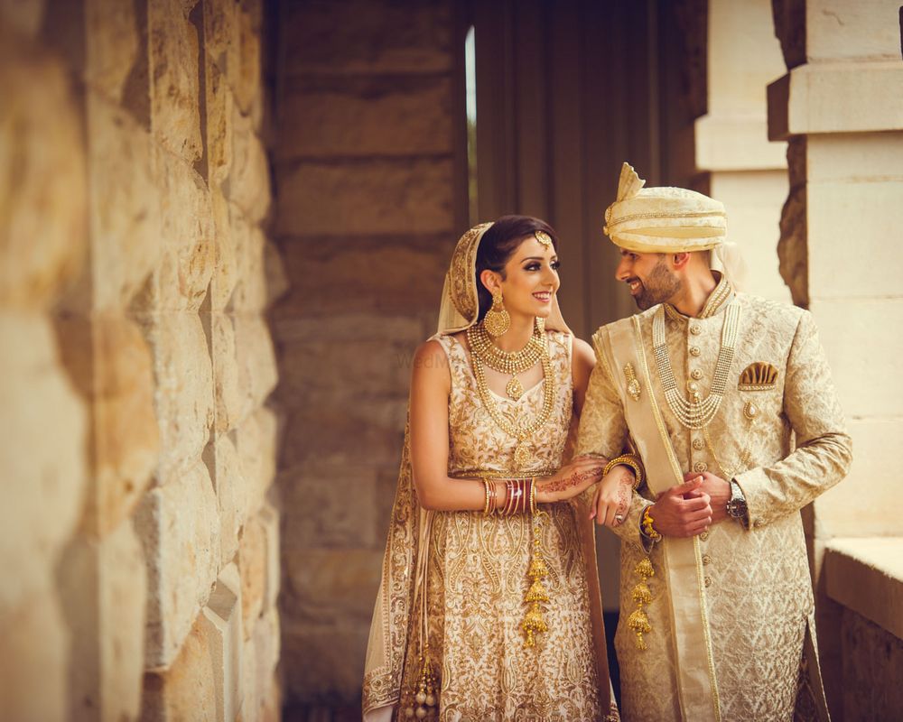 Photo of Colour coordinated bride and groom in ivory outfits