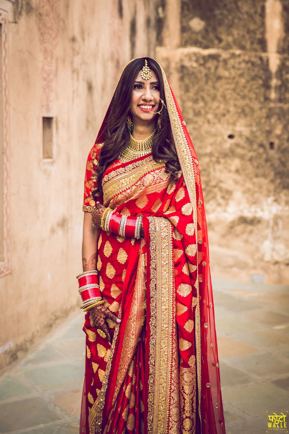 Photo of A bride in a red and gold benarasi saree on her wedding day