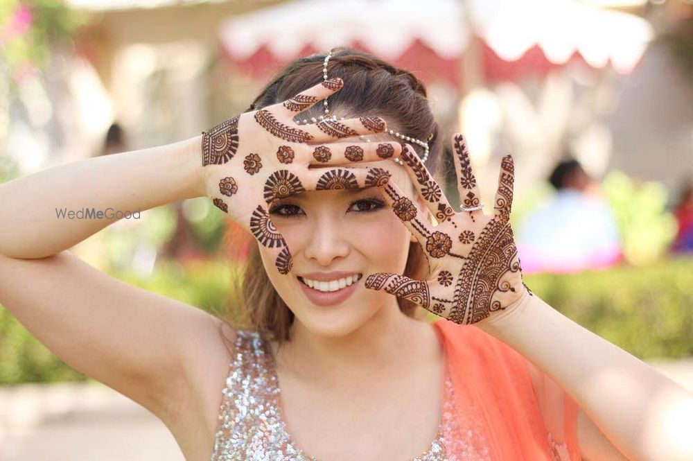 Photo of Spaced out buti mehendi design on hands