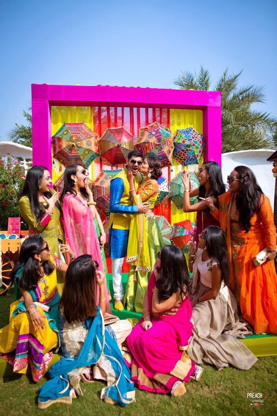 Photo of Couple with bridesmaids on mehendi with umbrella photobooth