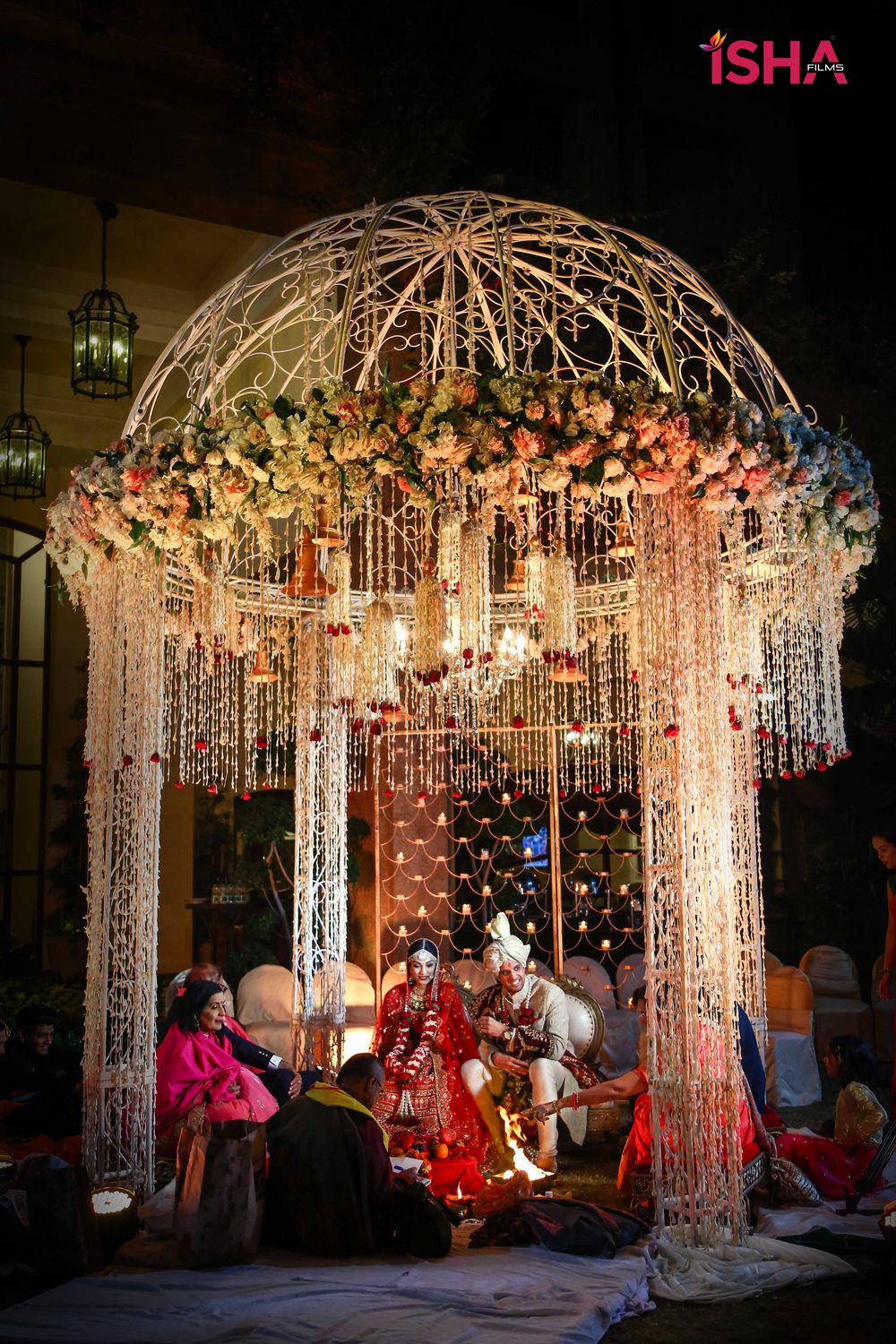 Photo of round mandap with hanging floral strings and iron structure