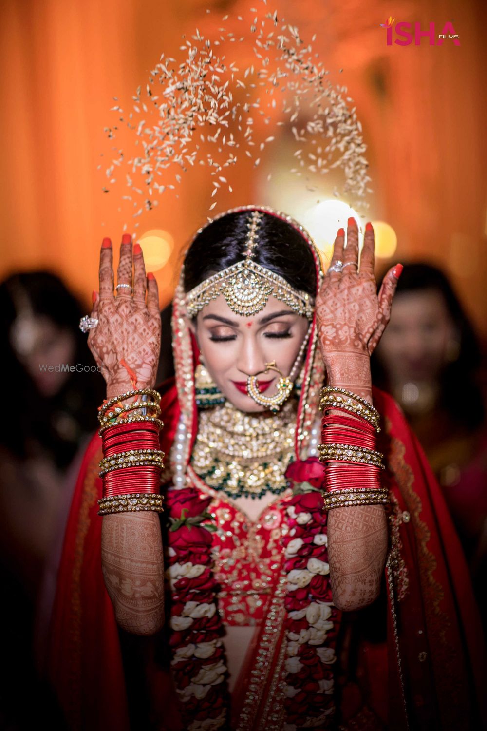 Photo of bride in red throwing rice bidaai portrait