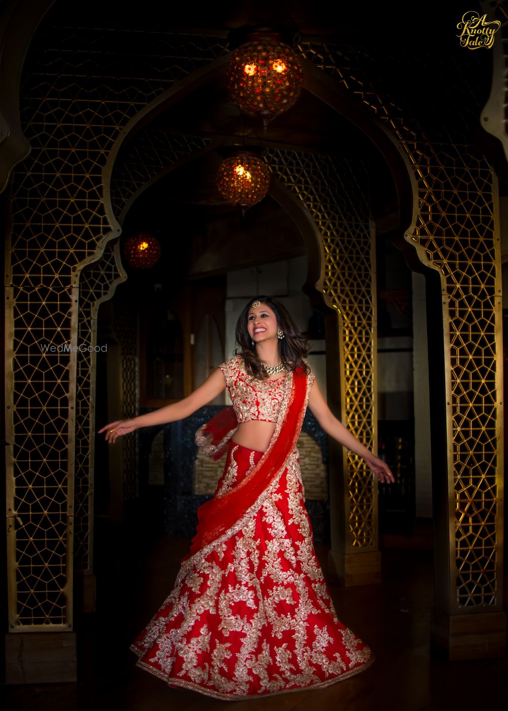 Photo of twirling bride in red and gold lehenga