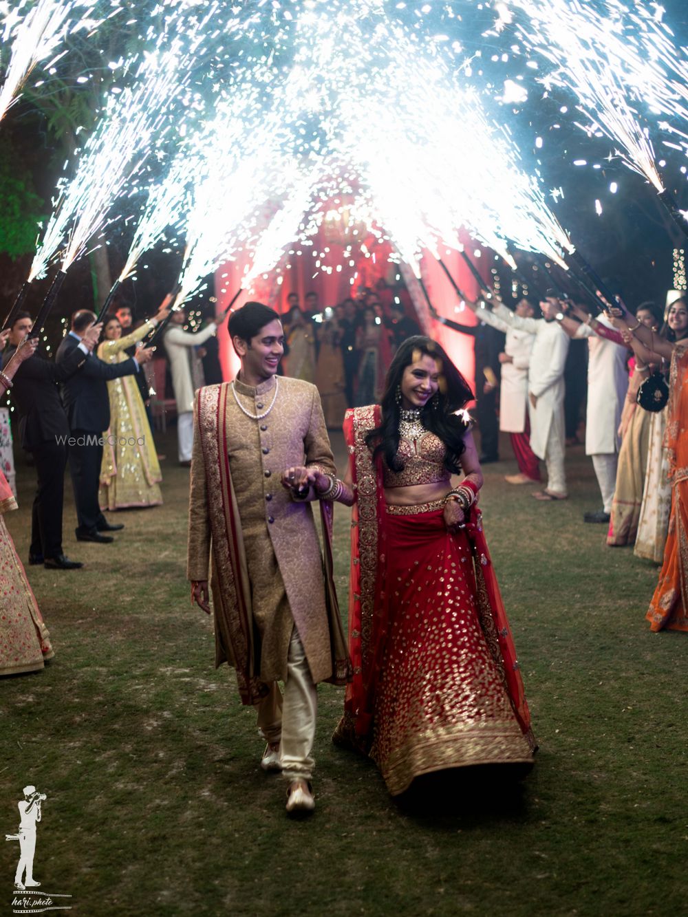 Photo of Outdoor wedding idea for bride and groom entry with guests holding cold pyros