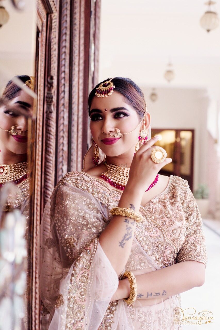Photo of Bride wearing embellished golden lehenga with contrasting jewellery.