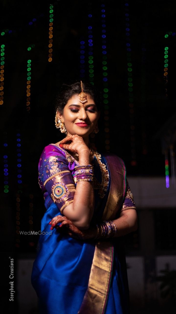 Photo of South Indian bride wearing a royal blue saree with a purple blouse.