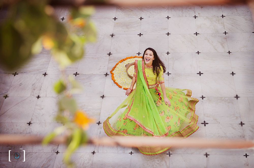 Photo of Bride twirling in green lehenga with yellow blouse