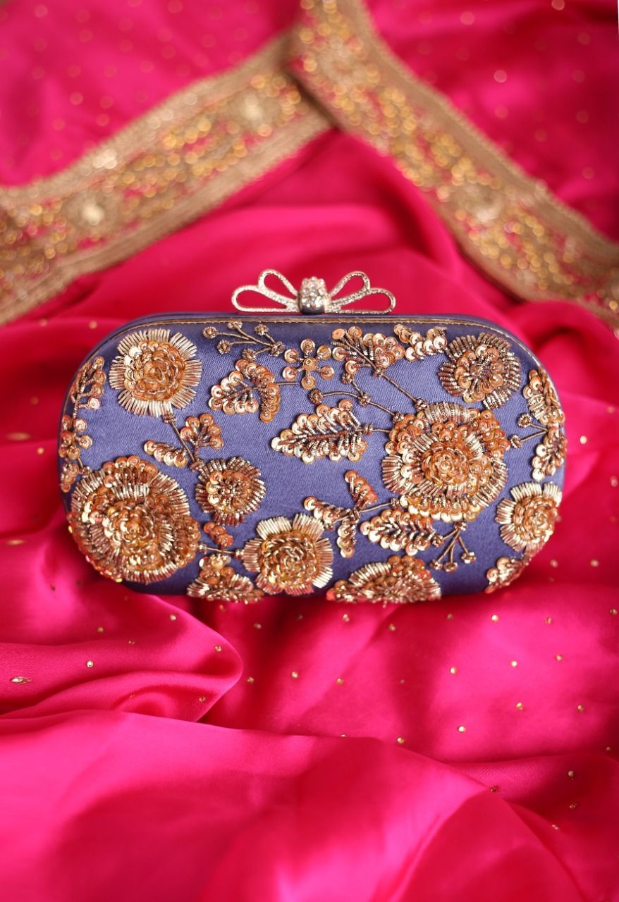 Photo of A blue clutch bag with sequined details.