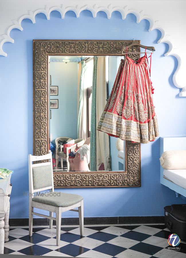 Photo of Red and Gold Lehenga on Hanger on Framed Vintage Mirror