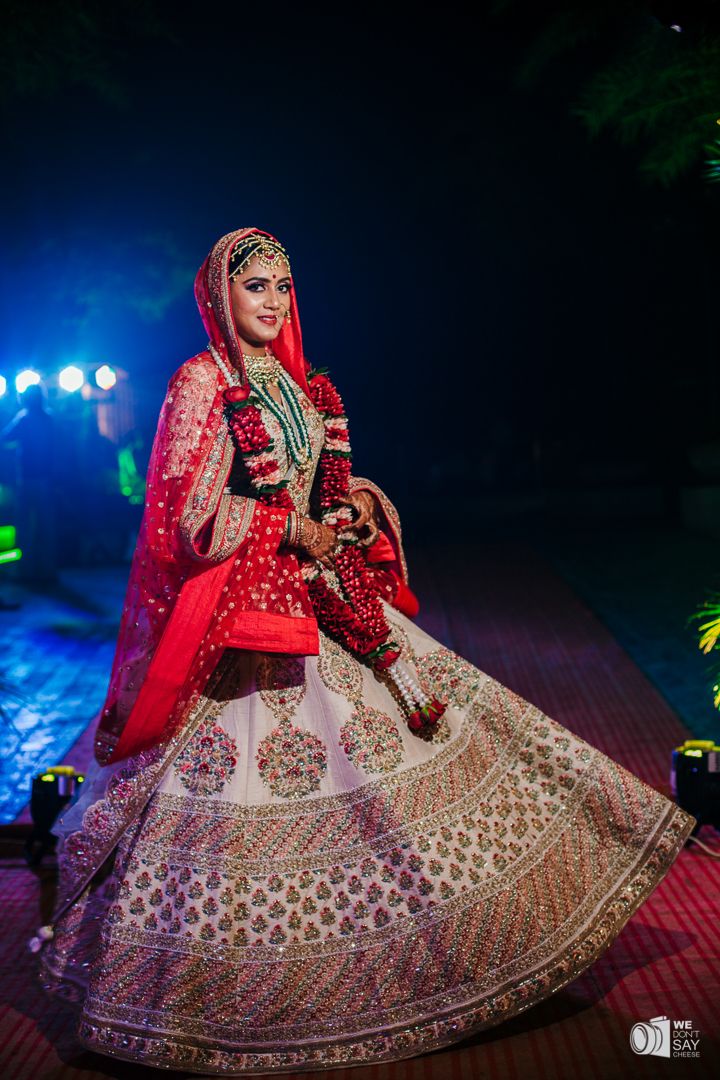 Photo of Stunning ivory lehenga with paneled work in multi colours and red bridal dupatta
