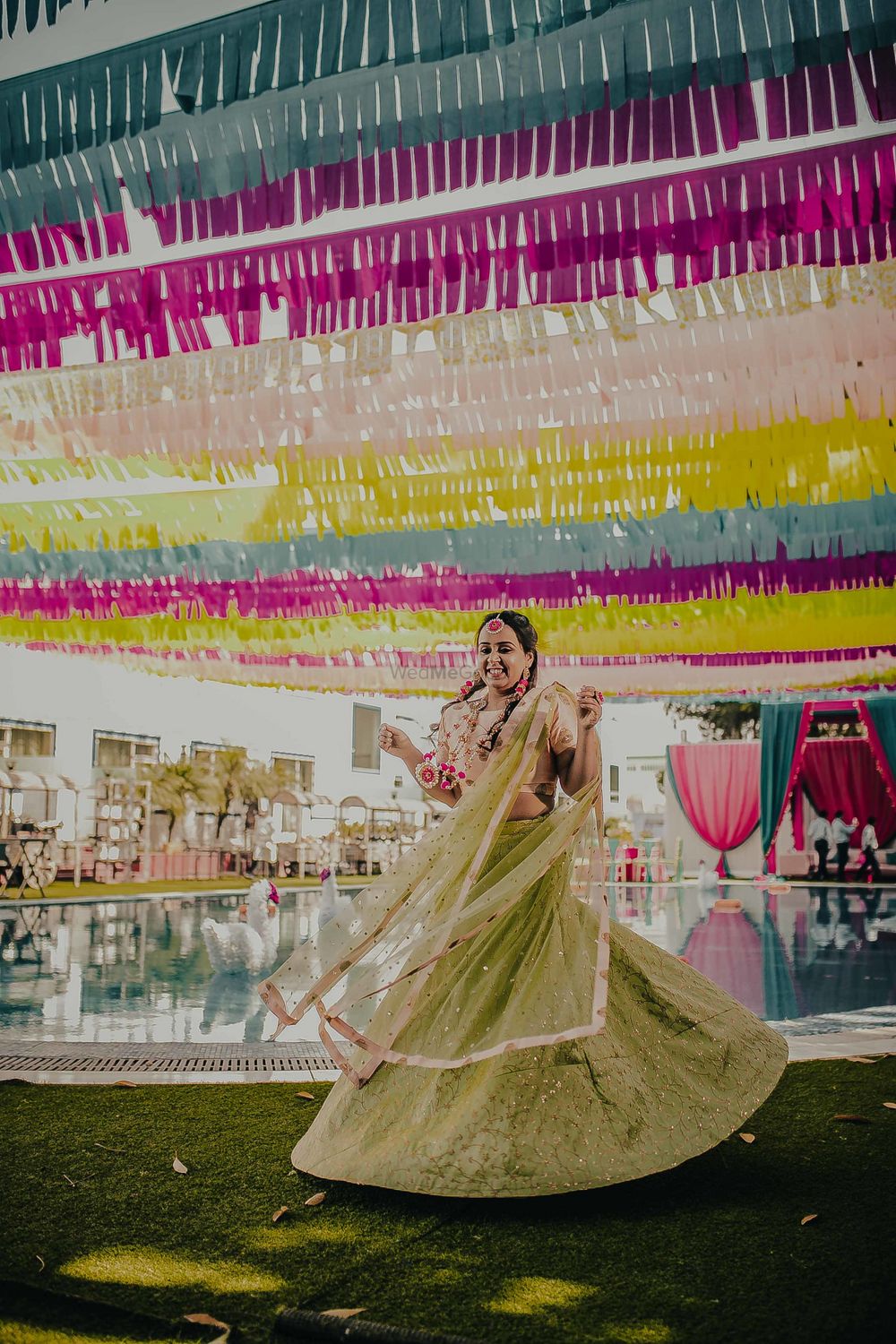 Photo of A bride in green twirling on her mehndi day