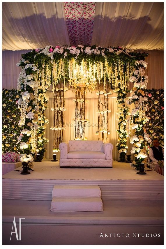 Photo of White theme floral stage decor