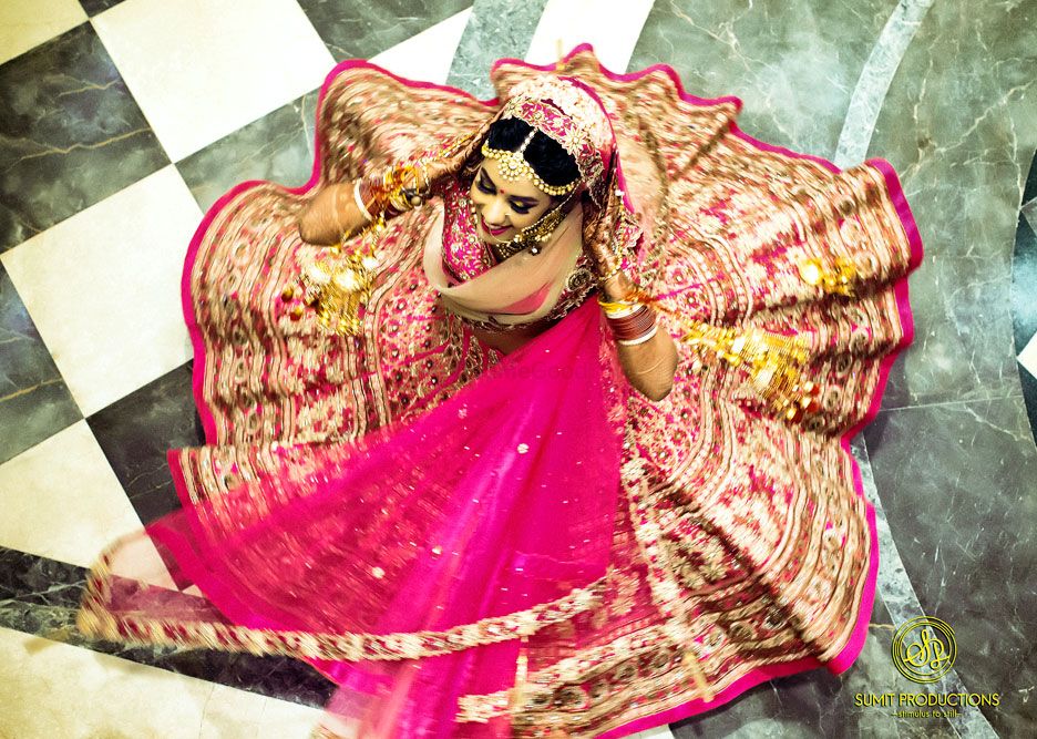 Photo of Twirling bride with flared out pink lehenga