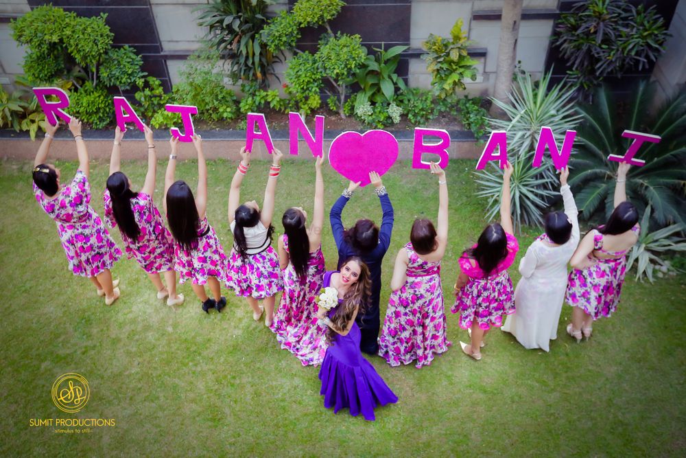 Photo of Bride with bridesmaids holding name props