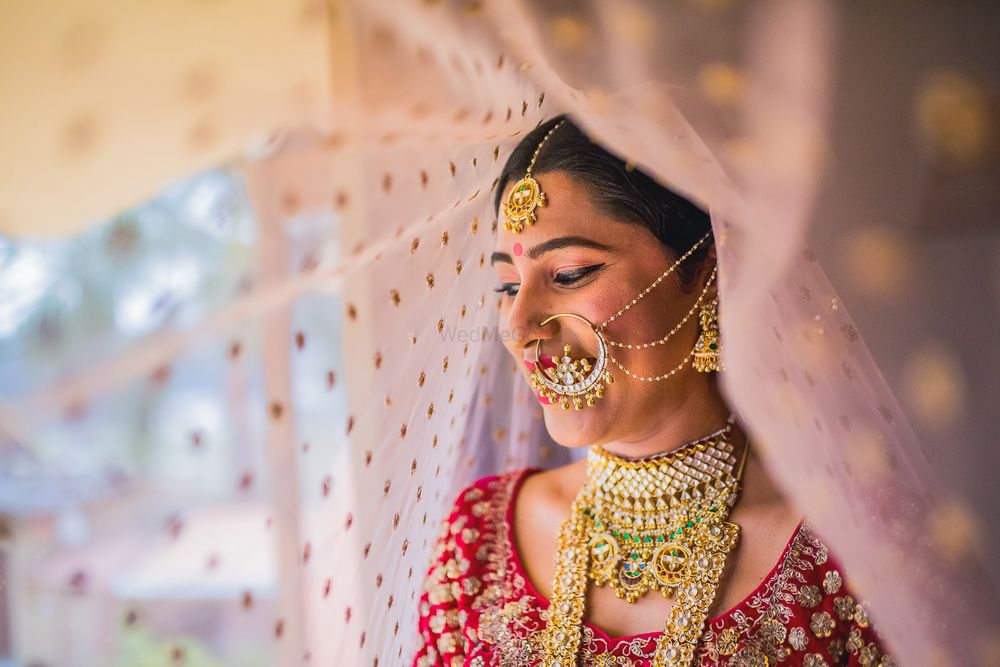 Photo of A bride poses for the camera in her red lehenga