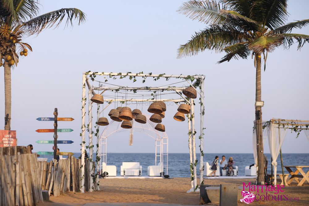 Photo of mandap with hanging cane baskets for beach wedding