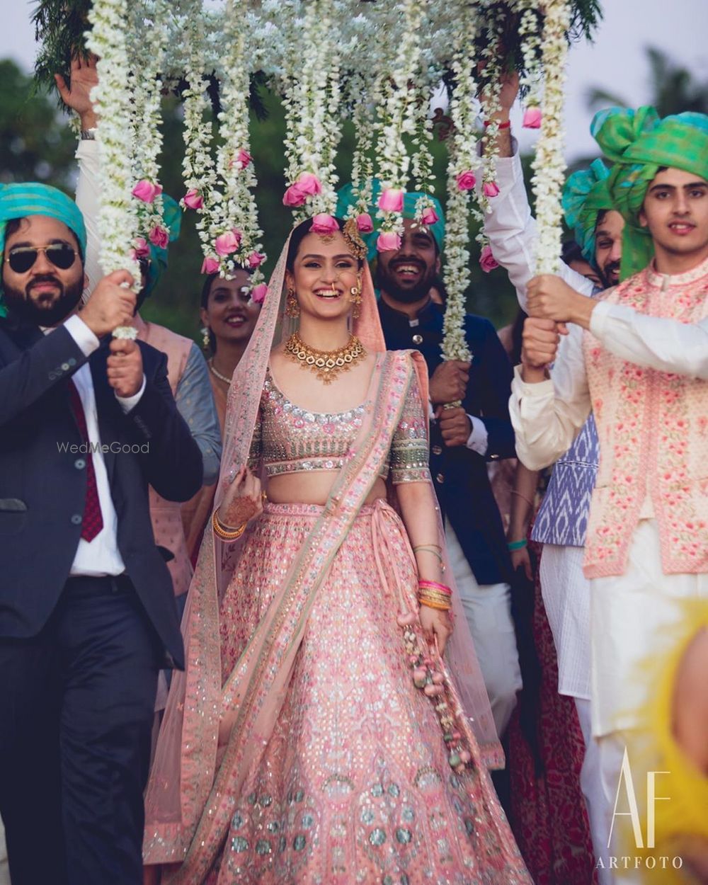 Photo of Bridal entry under a phoolon ki chaadar.