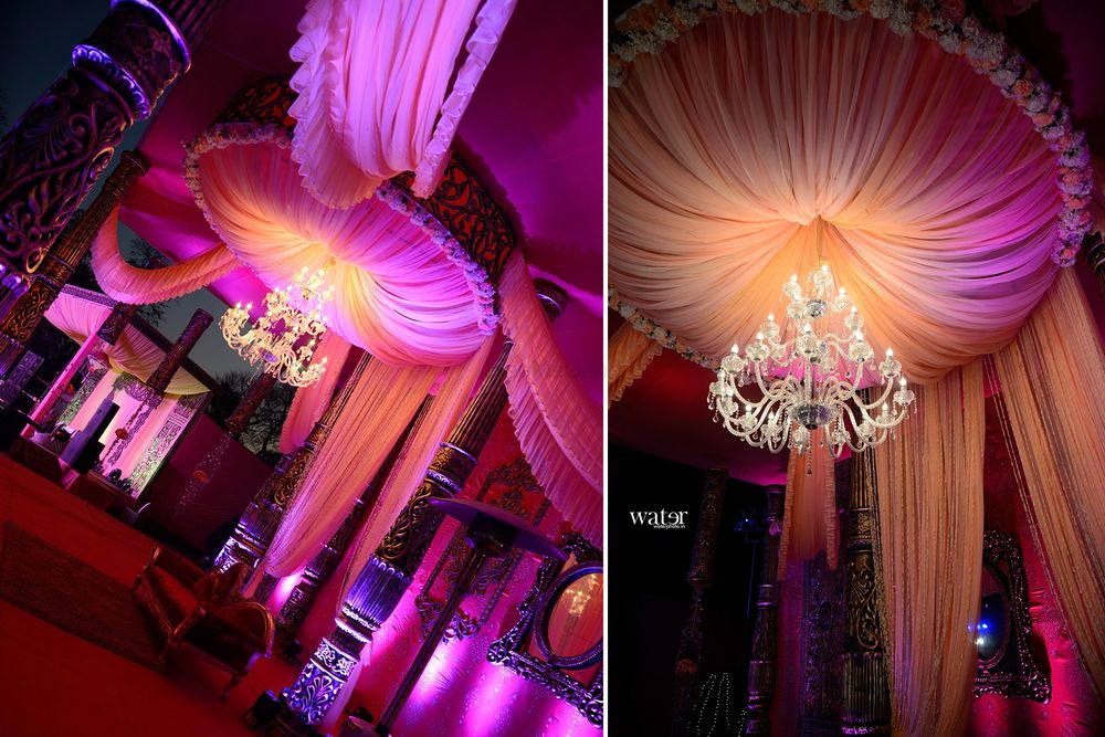 Photo of glamorous peach and purple engagement theme with mushroom ceiling and large crystal chandelier