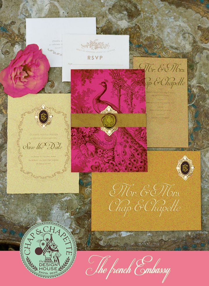 Photo of Pink and gold theme wedding card with peacock motif