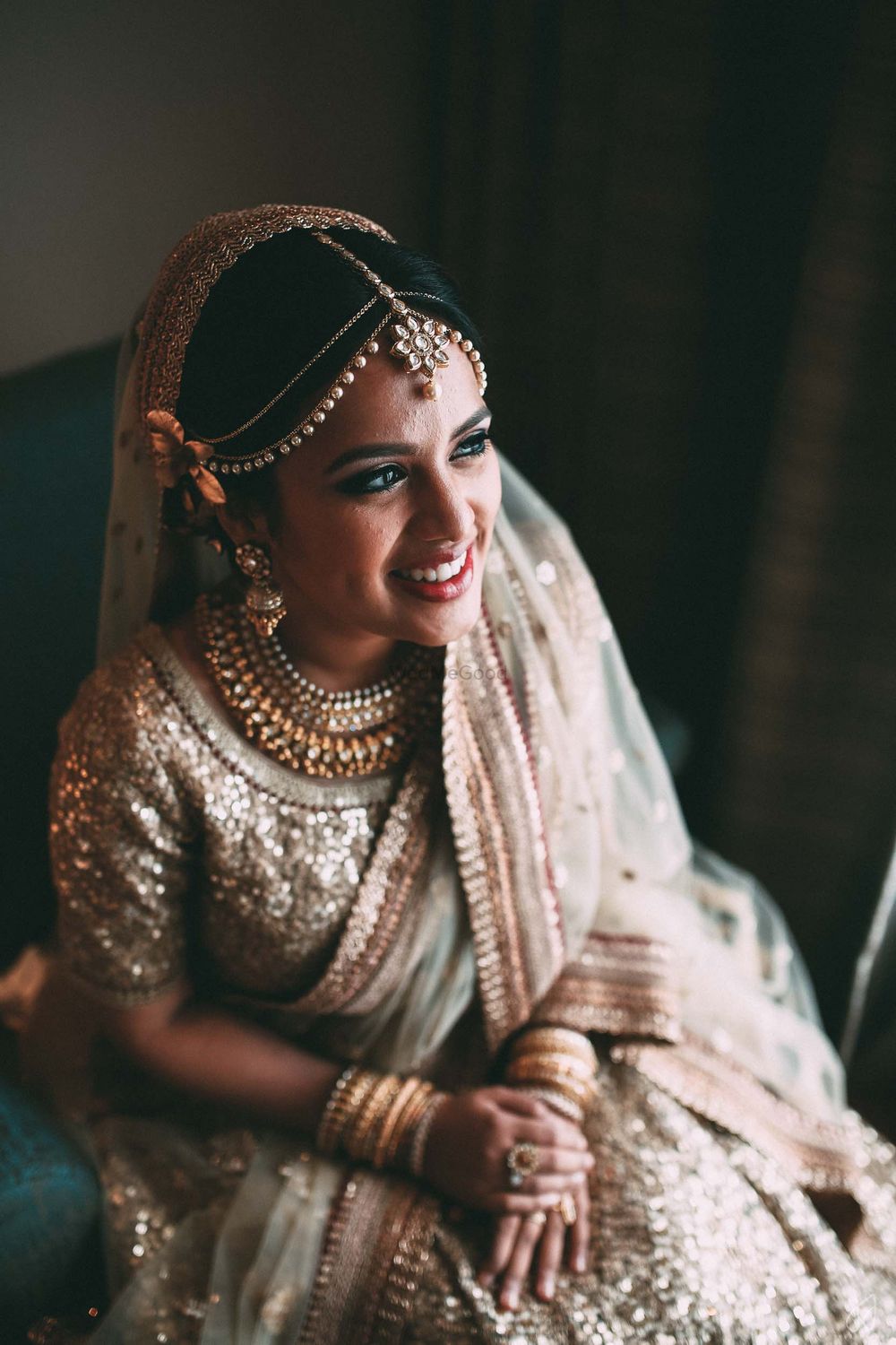 Photo of Smiling bride in gold sequin lehenga
