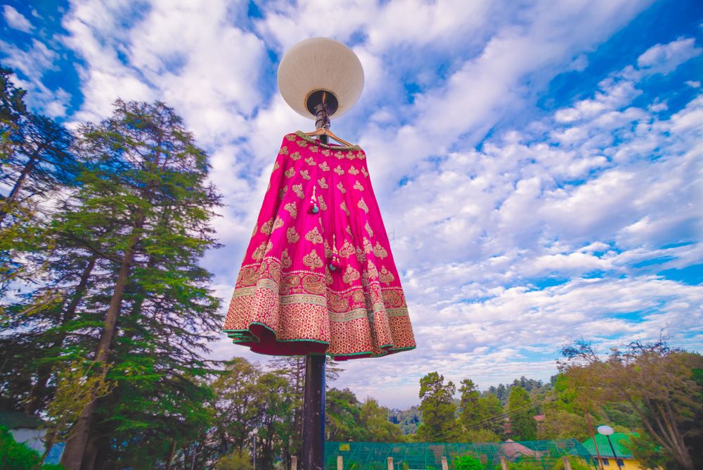 Photo of Bright pink and gold lehenga on lamp post outside