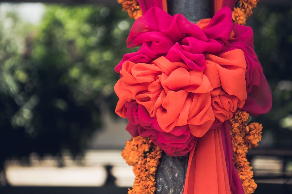 Photo of Pillar covered with cloth bow and floral strings