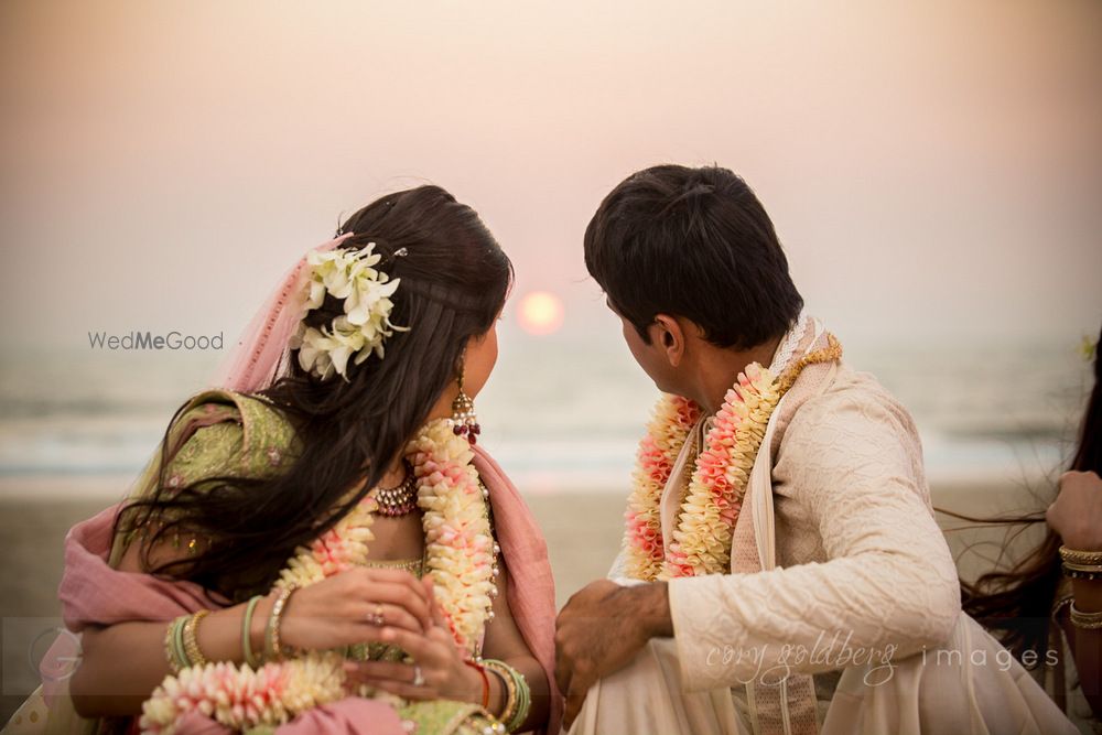 Photo of Beach wedding photo with couple looking at sunset