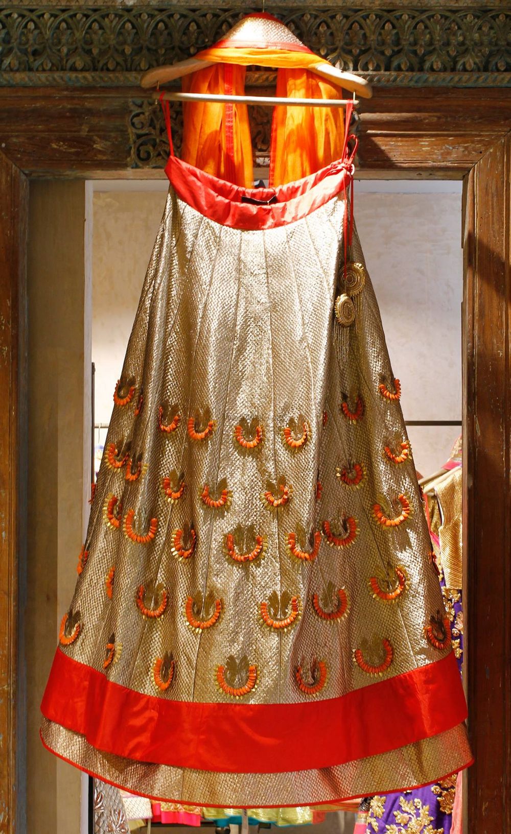 Photo of metallic gold sheen bridal lehenga with thin waistband and red border