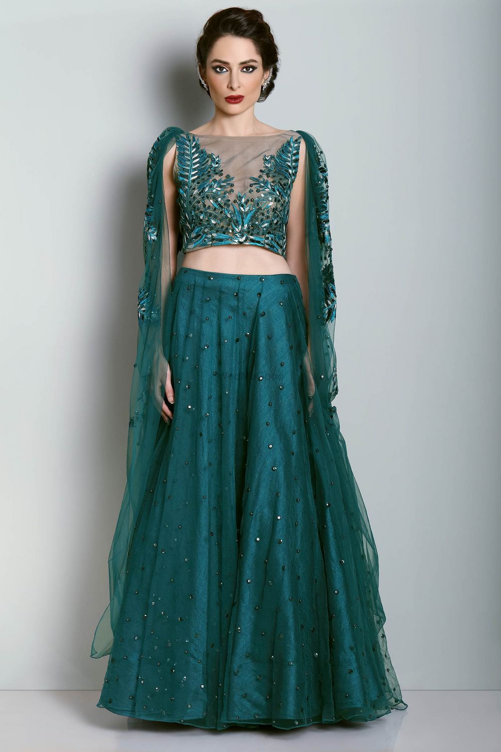 Photo of Teal light lehenga with shoulder embroidered cape