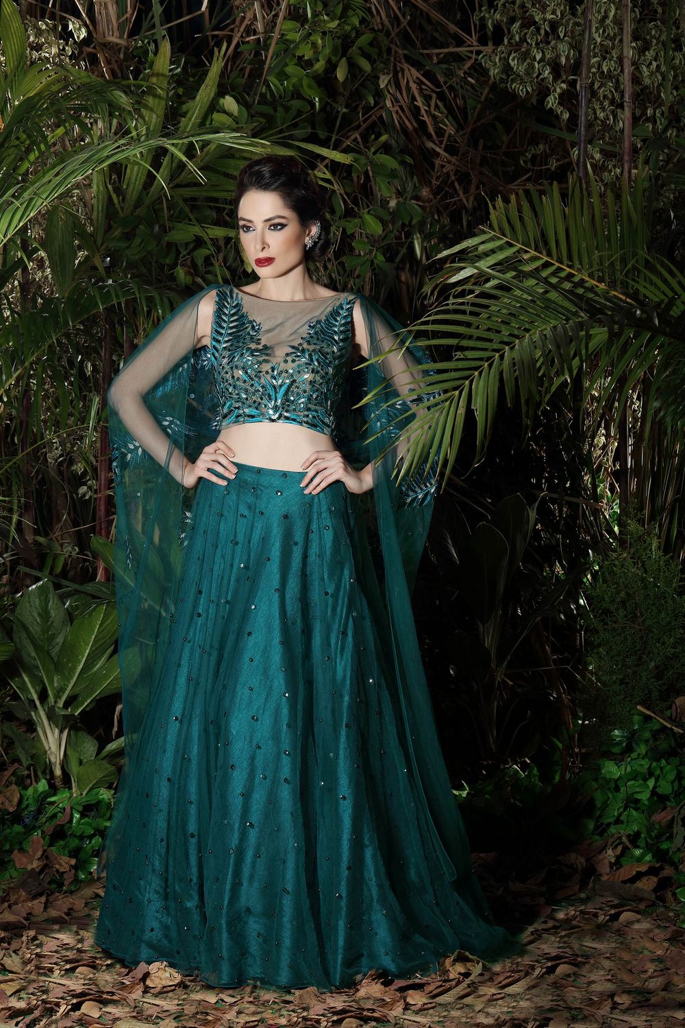 Photo of Teal light lehenga with shoulder embroidered net cape