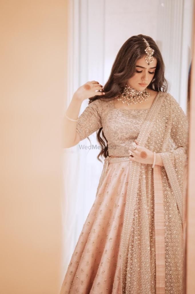 Photo of Candid shot of a bride dressed in a pastel lehenga.