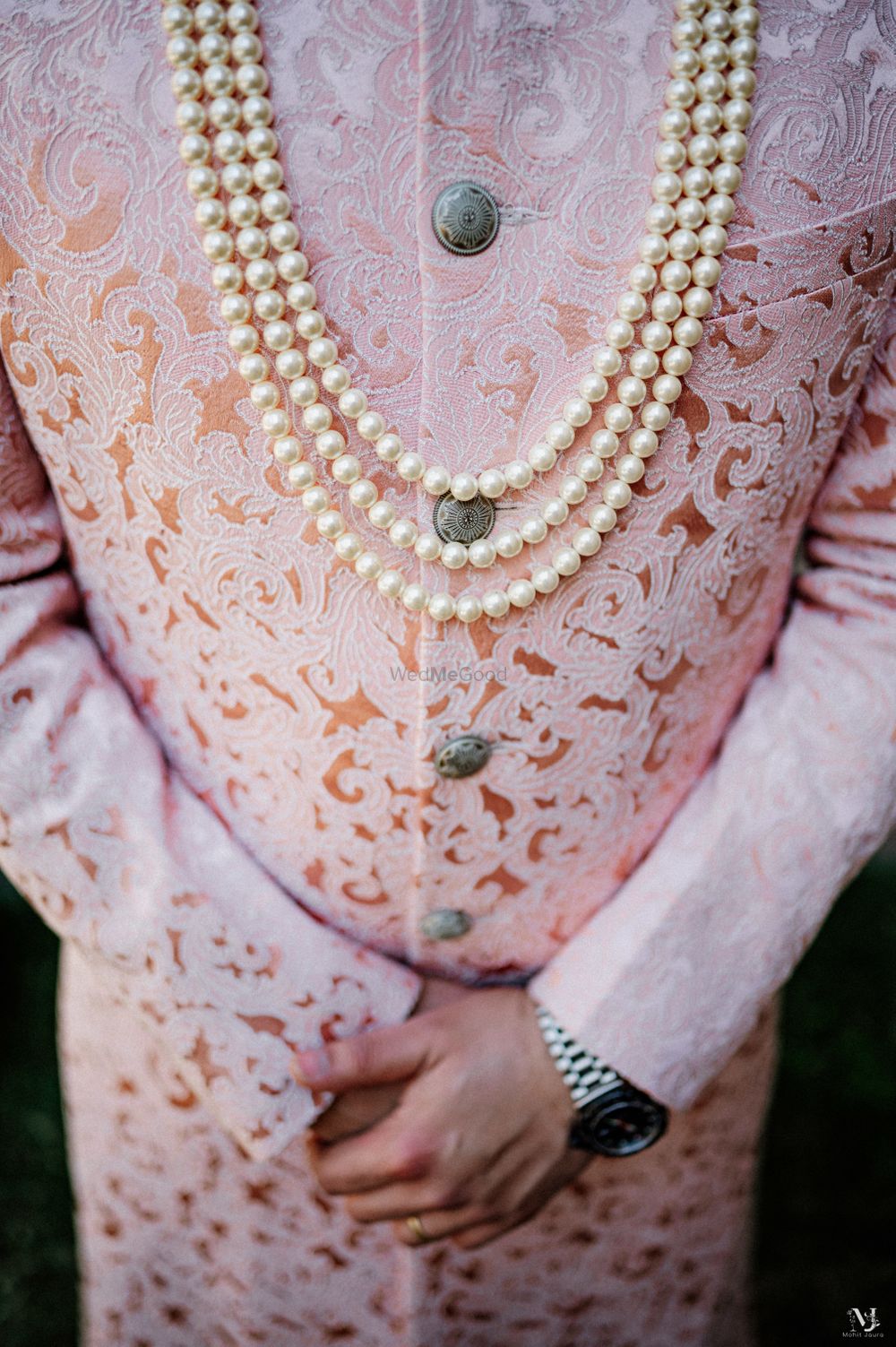 Photo of Groom wearing textured sherwani with a pearl mala.