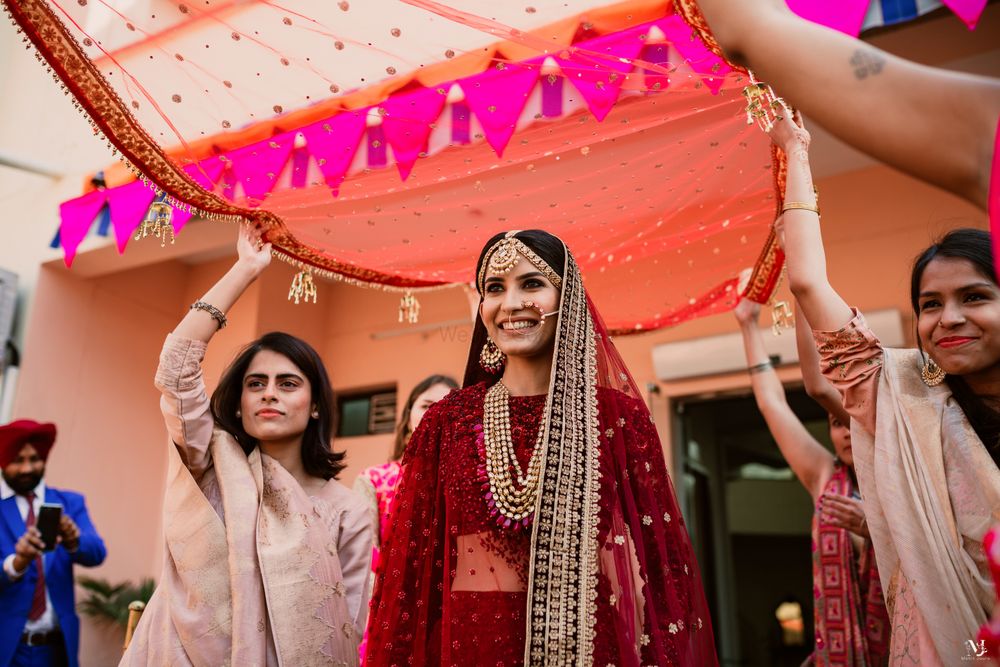 Photo of Bride making an entry under a dupatta.