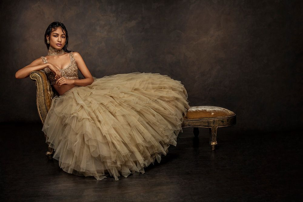 Photo of gold light lehenga with poofy lace and feather and bustier metallic blouse with dupatta