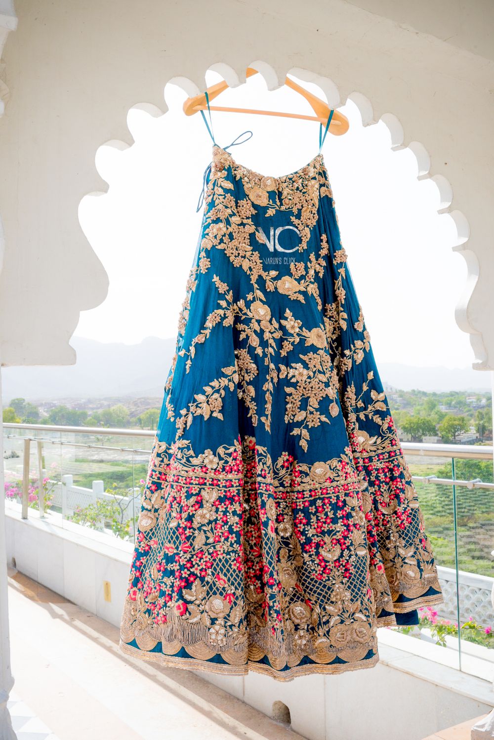 Photo of blue silk lehenga with floral leaf pattern going all over it and large intriicate border
