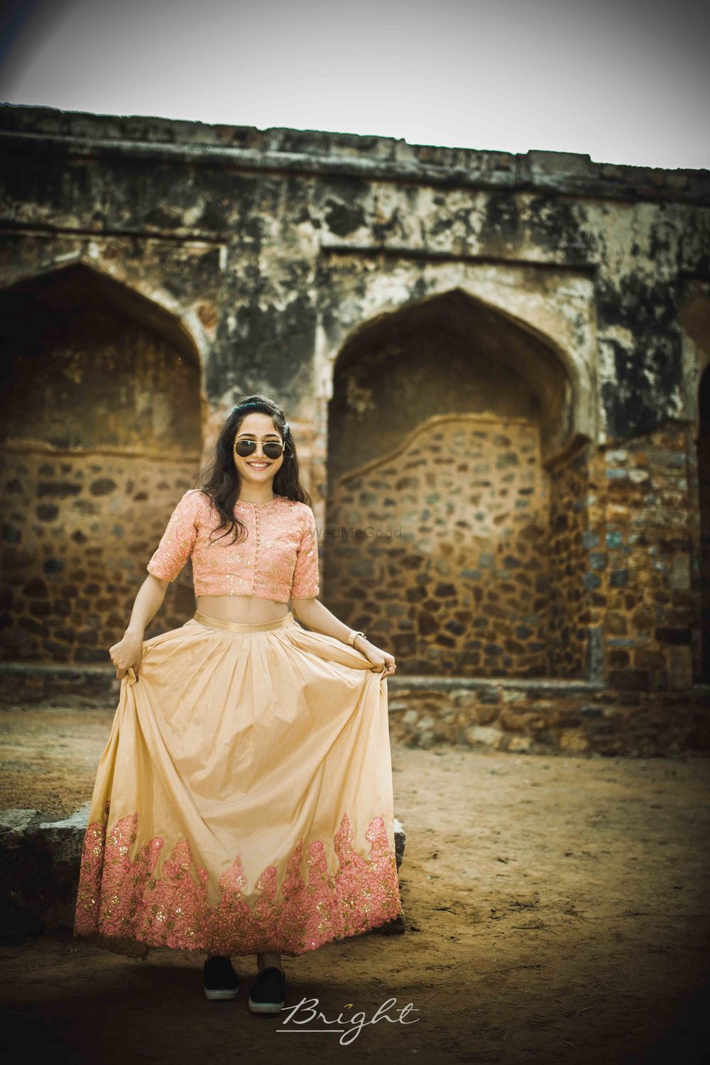 Photo of bride wearing peach and yellow lehenga with sneakers