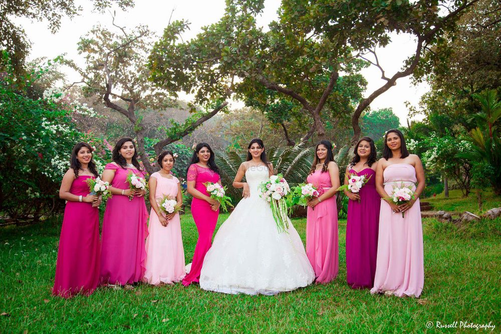 Photo of Bride in white gown with matching bridesmaids in pink