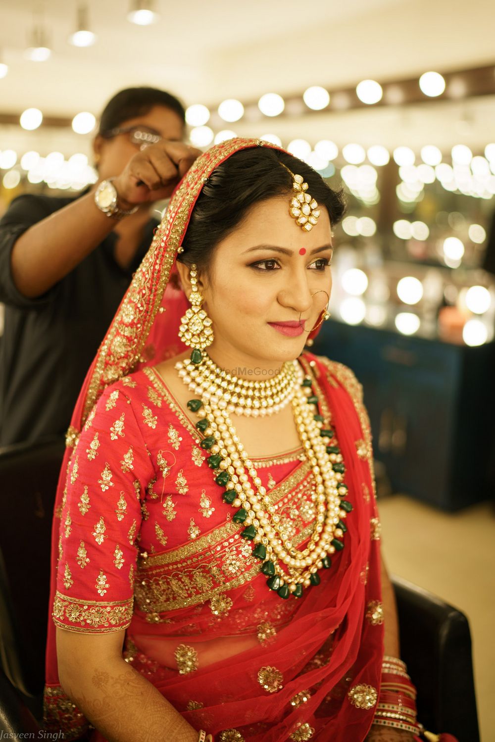 Photo of Contrasting green and gold jewellery with red bridal lehenga