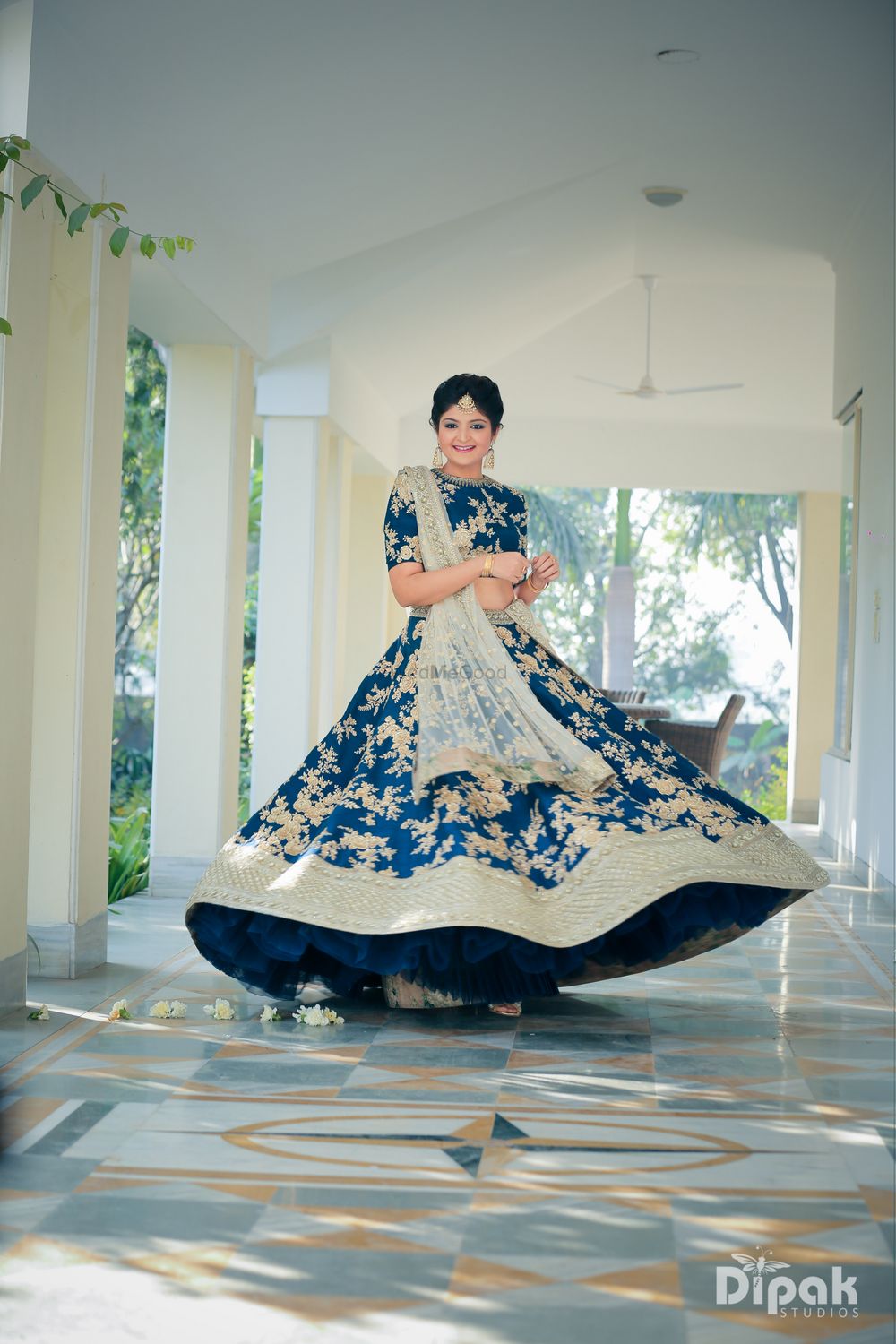 Photo of Bride twirling in blue lehenga with floral motifs