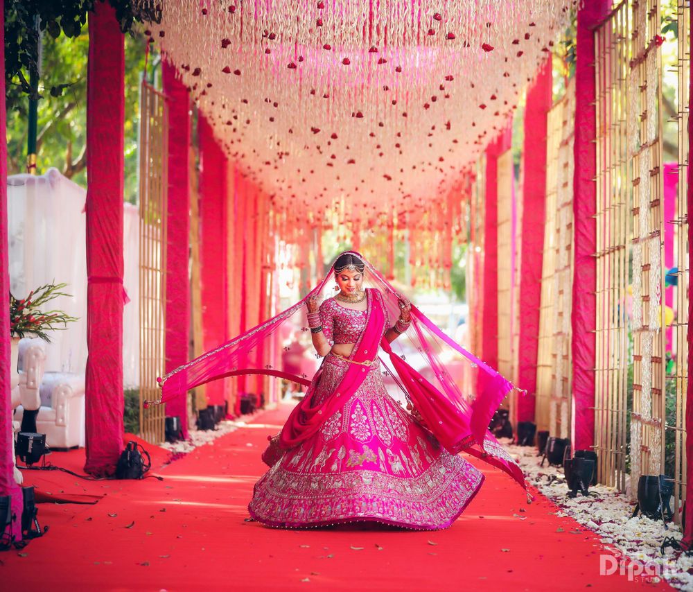 Photo of Twirling bride in hot pink bridal lehenga