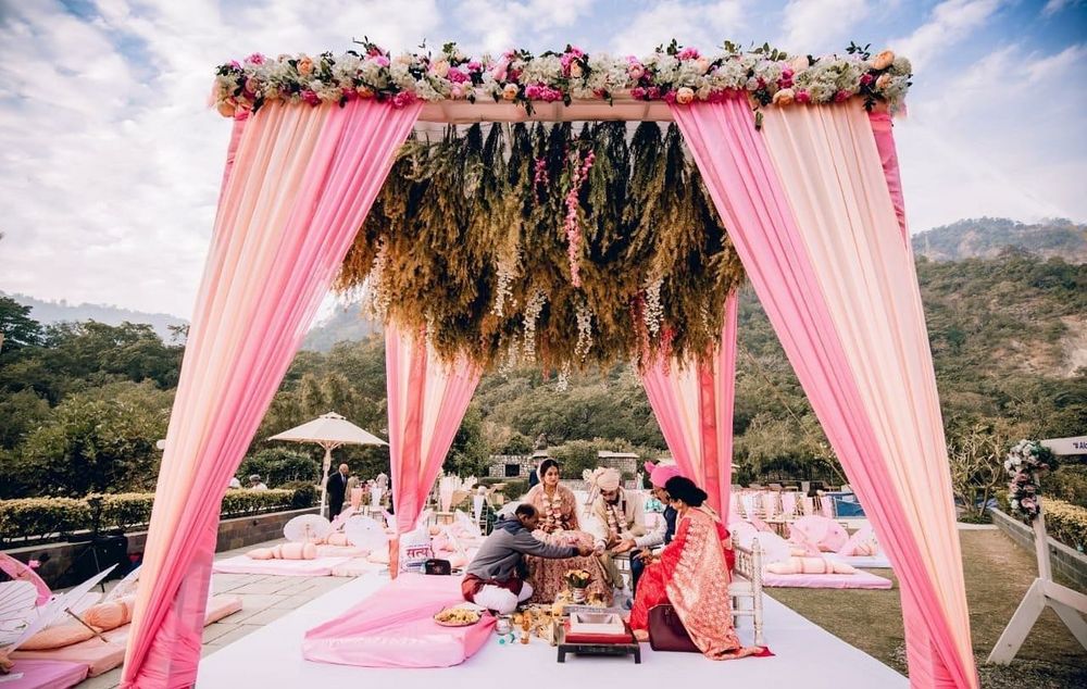 Photo of simple mandap decor with drapes and botanicals
