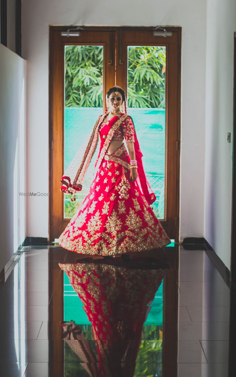 Photo of Twirling bride in red and gold lehenga