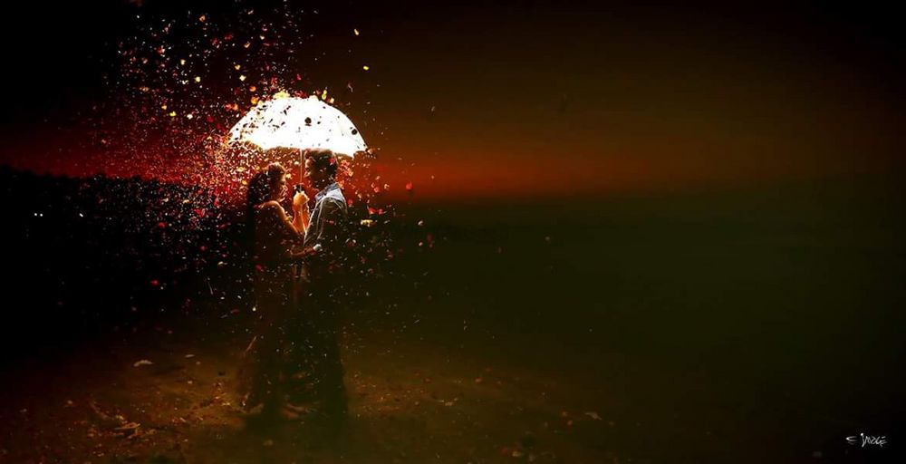 Photo of romantic couple shot with rose petals shower