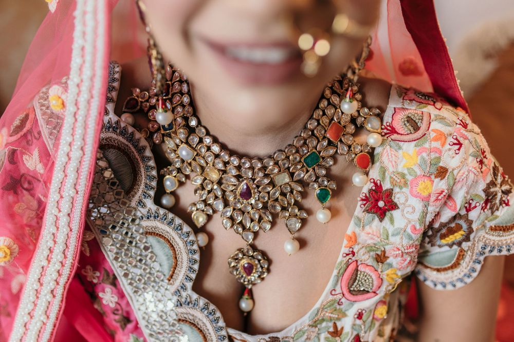 Photo of Bride wearing a navaratna necklace with a scalloped blouse.