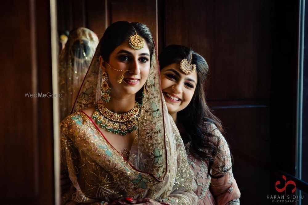 Photo of A happy picture of a bride with her bridesmaid